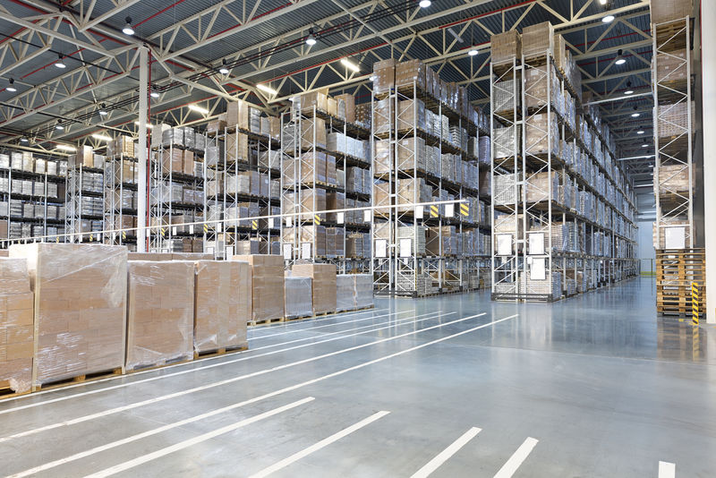 Ogromno distribucijsko skladište s kutijama na visokim policama